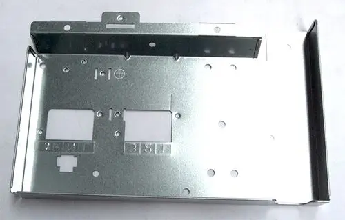 Metallabdeckung für eine Klemmleiste, möglicherweise von Daikin, mit Öffnungen und Ausschnitten für Kabelanschlüsse, auf einer hellen Oberfläche.